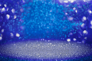 Blue and silver twinkling lights bokeh background. Abstract glitter background with selective...