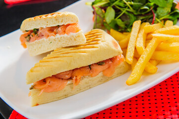 Toasts with red salmon served with french fries and salad
