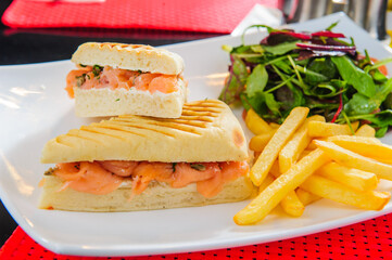 Toasts with red salmon served with french fries and salad