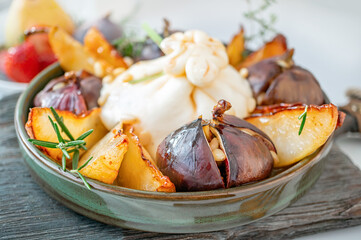 Buratta with caramelized pears and figs baked with honey. Pine nuts complement the dish