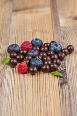 Obraz na płótnie Canvas Blackberries coated with milk chocolate in a blue ceramic bow