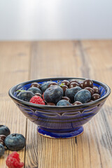 Blackberries coated with milk chocolate in a blue ceramic bow