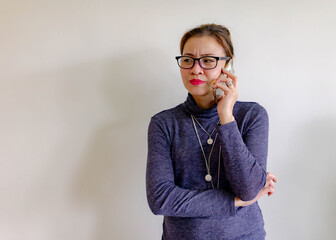 Angry Asian business woman talking on cell phone. Isolated on white.