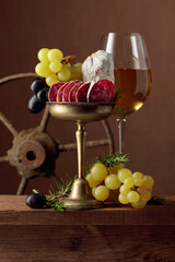 Glass of wine with snacks on a brown background.