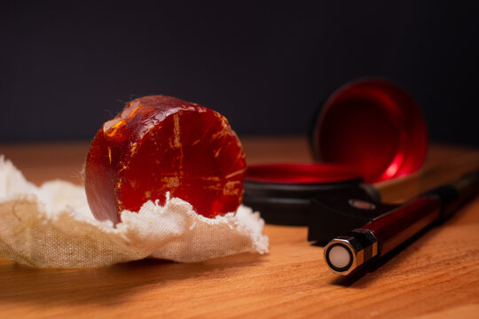 Closeup Red Violin resin (rosin) with a bow