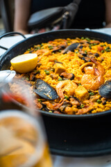 Big iron pan with seafood paella with lemon, mussels, squid, calamari in Spain. Delicious spanish cuisine food