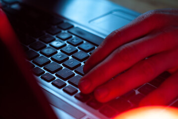a man working in a laptop close-up, hands on the keyboard,