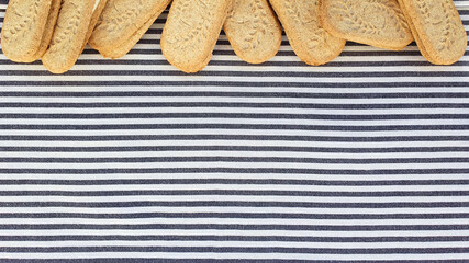 Cookies border / frame on striped textile background. Top view, flat lay style.