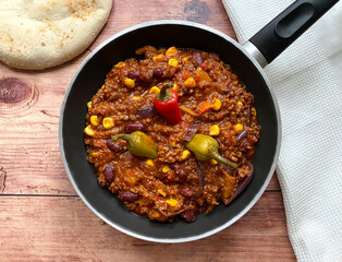 Chili con carne with minced beef, tomatoes, chili peppers, beans, corn, onions, garlic and bell...