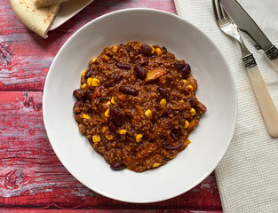 Chili con carne with minced beef, tomatoes, chili peppers, beans, corn, onions, garlic and bell pepper. Served with flat bread.