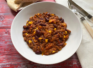 Chili con carne with minced beef, tomatoes, chili peppers, beans, corn, onions, garlic and bell pepper. Served with flat bread.