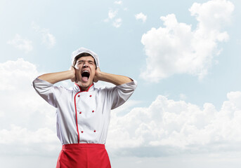 Fototapeta premium Young male chef screaming in shock and horror