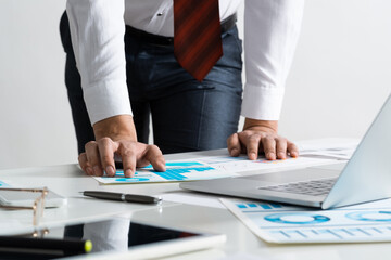 Businessman in suit and tie standing near desk