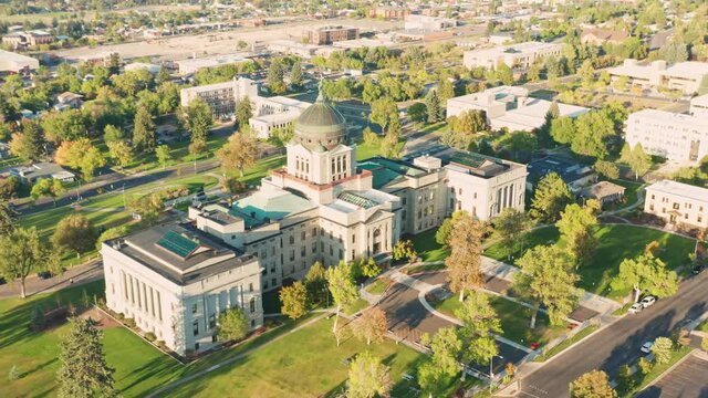 Aerial establishing shot of Montana State Capitol in Helena on a sunny afternoon with hazy sky caused by wildfires. The Montana State Capitol houses the Montana State Legislature.