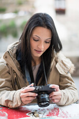 woman reviewing her images on camera in bar terrace