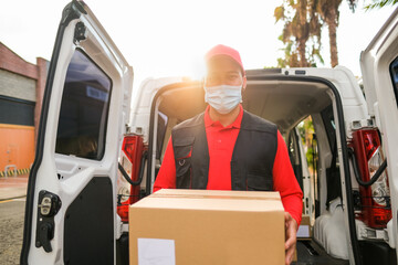 Delivery man with package while wearing surgical face mask - Work with safety measures for coronavirus