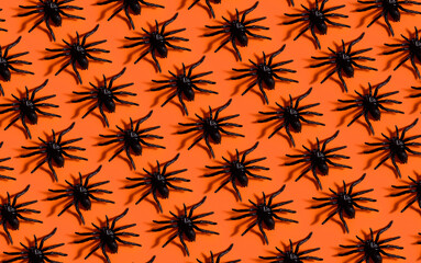 Halloween background pattern. Scary black spider on orange paper. Minimal pop art design for halloween party concept.