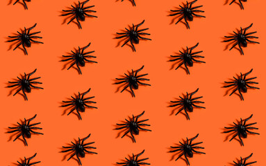 Halloween background pattern. Scary black spider on orange paper. Minimal pop art design for halloween party concept.