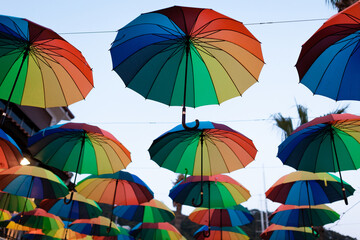 Lots of colored umbrellas hanging in the air