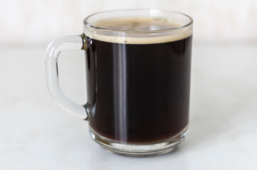 A cup of hot chicory on white table front view