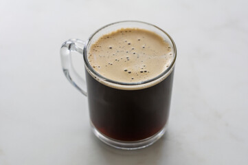 A cup of hot chicory on white table
