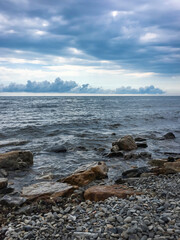 Beach with big rocks before the storm on the sea