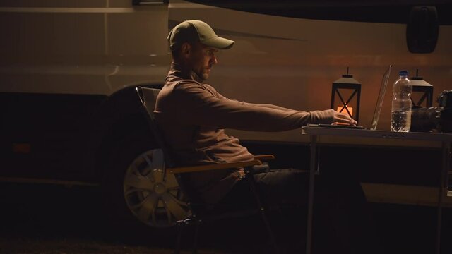 Caucasian Men in His 40s Working From His Laptop Remotely While Staying Outdoor. Wireless Technology Theme.