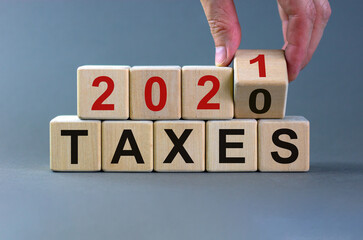 Business concept of planning 2021. Male hand flips wooden cube and change the inscription 'Taxes...