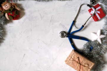 Christmas flat lay. Concept of celebrating christmas and new year in the healthcare industry. Top view. Blue stethoscope on a white background.