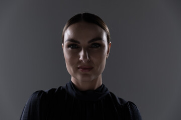 Portrait of young woman against grey background