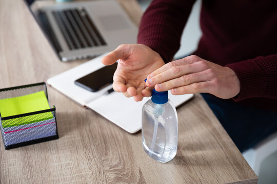 Mid section of man sanitizing his hands
