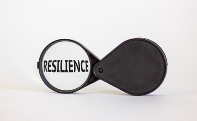 Magnifying glass with word 'resilience' on beautiful white background. Business concept, copy space.