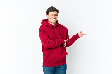 Young cool man smiling cheerfully pointing with forefinger away.