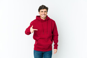 Fototapeta premium Young cool man person pointing by hand to a shirt copy space, proud and confident