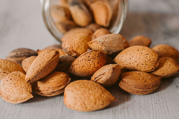 Almonds in a jar on wooden rustic table as background. Organic and healthy food. 