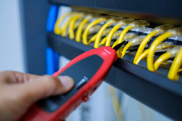 Network tester tools and system administrators will test the network cable in technogy data center room.