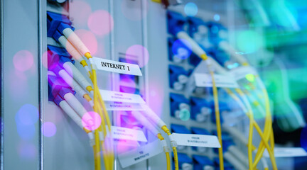 Fototapeta na wymiar Yellow fiber optic cable with lighting of fiber optics and high speed network router switch in a technology data center room. widescreen
