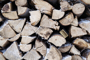 Fototapeta premium Natural background, stack of wood with snow between them.