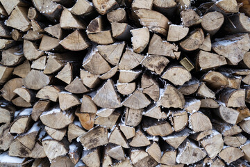 Natural background, stack of wood with snow between them.