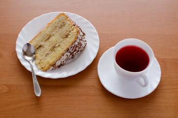 One white cup of tea and cake.
