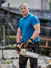 Farmer with chainsaw cutting wood