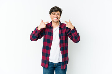 Fototapeta premium Young cool man smiles, pointing fingers at mouth.