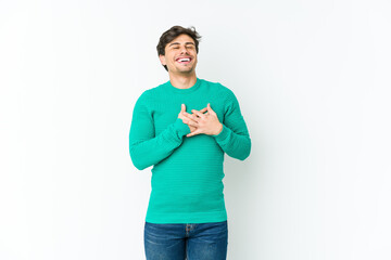 Young cool man laughing keeping hands on heart, concept of happiness.