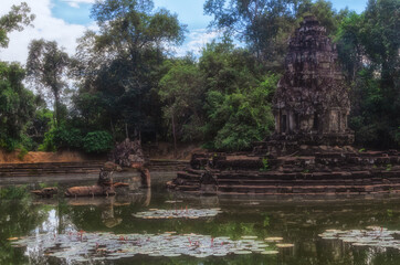 Fototapeta na wymiar Neak Pean island temple with reflections and lotus flowers, Angkor temples complex, Siem Reap