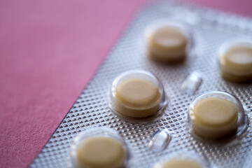 Pills on a pink background. The medicine. Macro photography, soft focus.