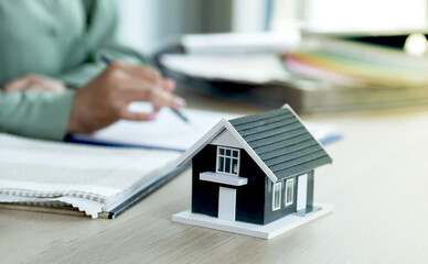 Home model standing in front of  the property and interior agents are presenting houses and curtains for interior decoration