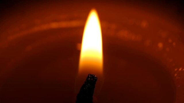 Stearin candle burns on black background high resolution video clip close-up