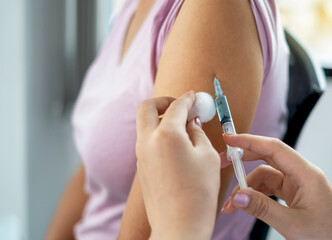 The doctor's hand holding a syringe and was about to vaccinate a patient in the clinic to prevent the spread of the virus