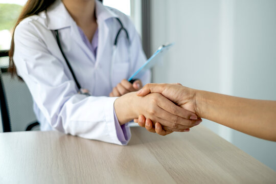 Doctors and patients shaking hands after knowing the results of the health examination, medical checkup concept