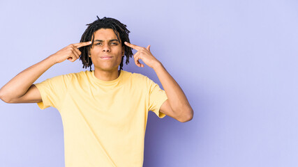 Young african american rasta man focused on a task, keeping forefingers pointing head.